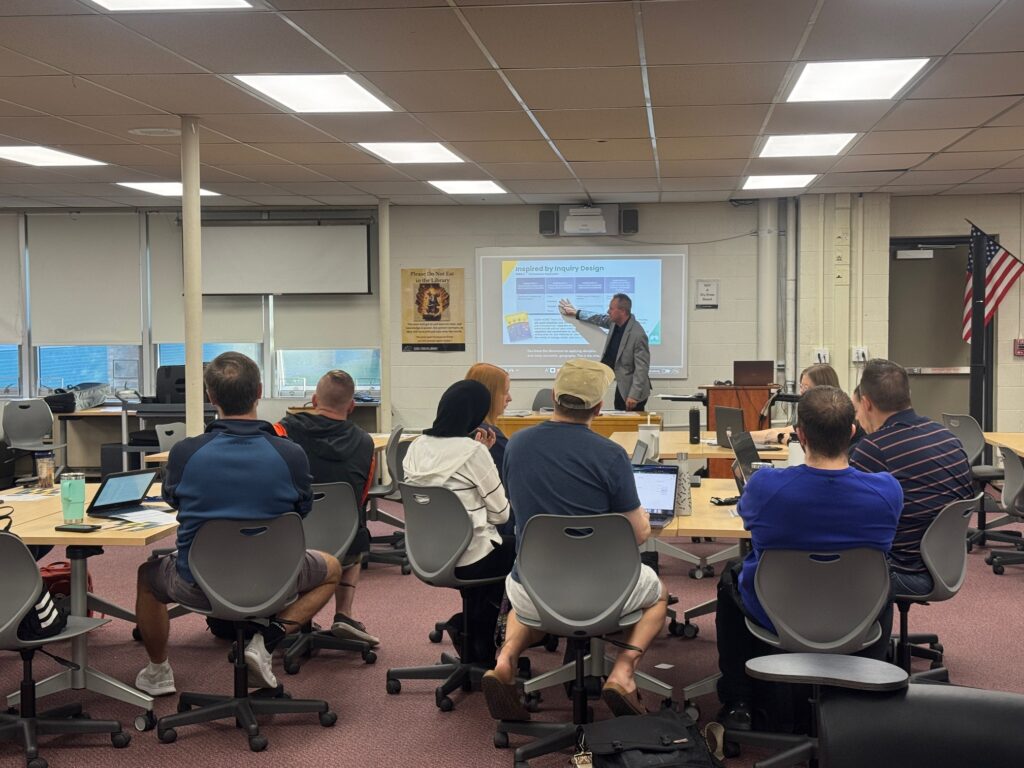 A man giving a presentation to a room of teachers.